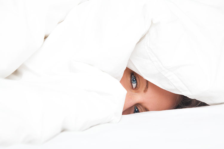 حاربي الخمول في رمضان Woman-sleeping-with-head-under-comforter-and-bed-sheets