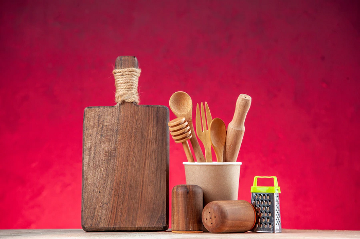 top-view-wooden-spoon-empty-plastic-coffee-pot-cutting-board-grater-pink-surface_140725-94279